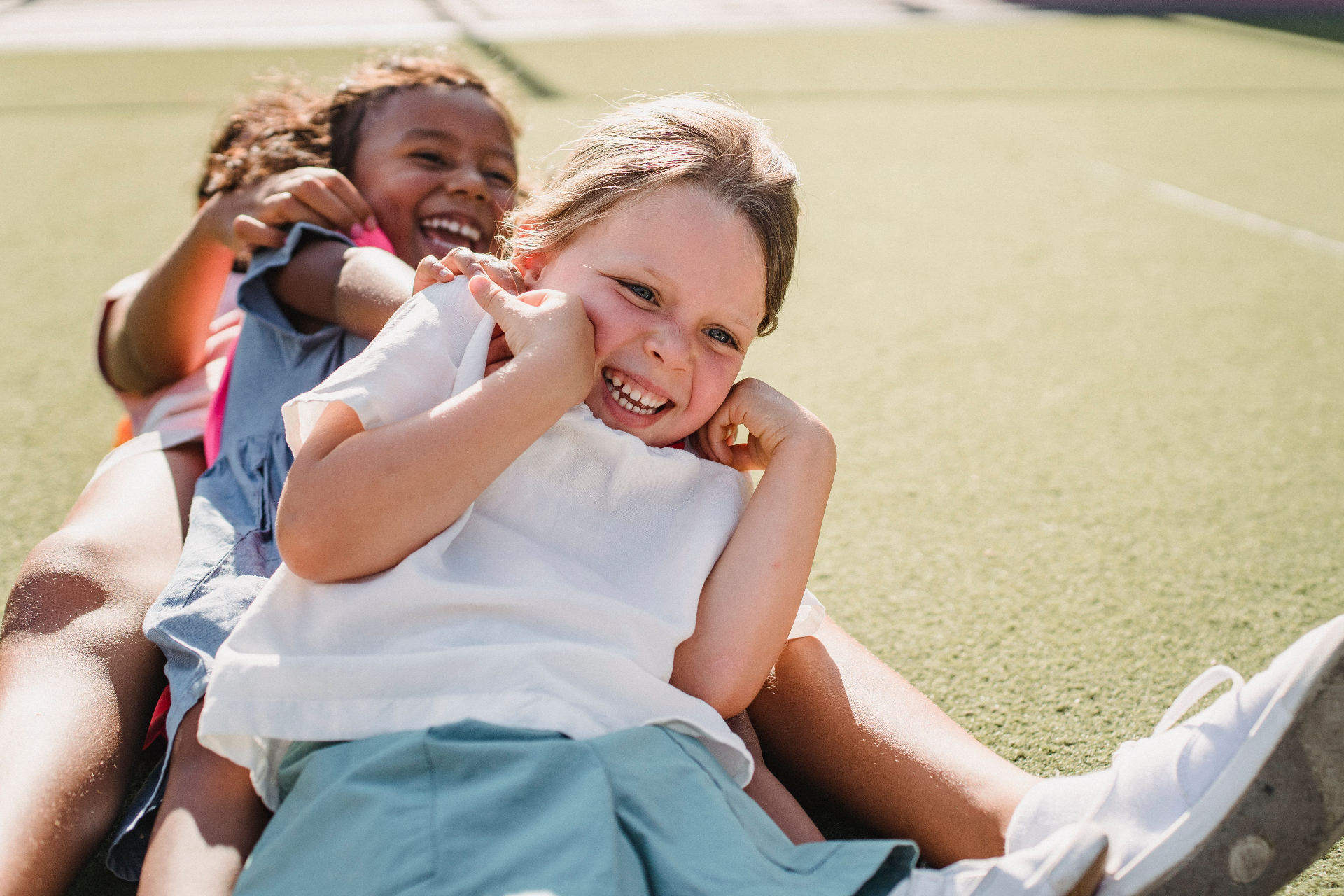 Two children smiling and playing together outdoors